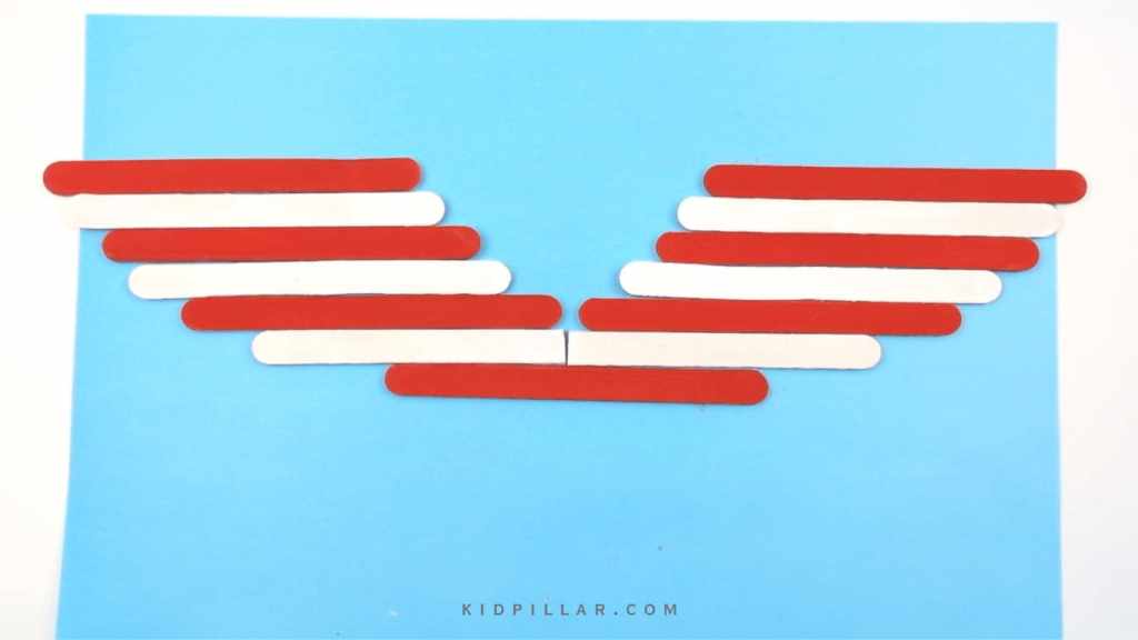 Arrange crafts sticks on paper to make wings for Eagle Craft